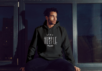 Man wearing a black hoodie with text sitting in front of a window at night