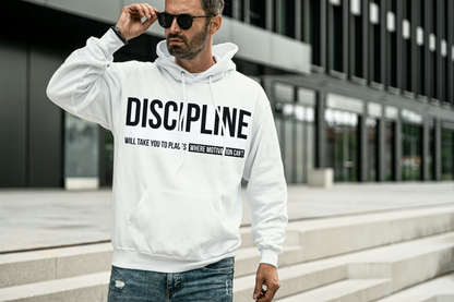 Man wearing a white hoodie with 'DISCIPLINE' text, standing outdoors.