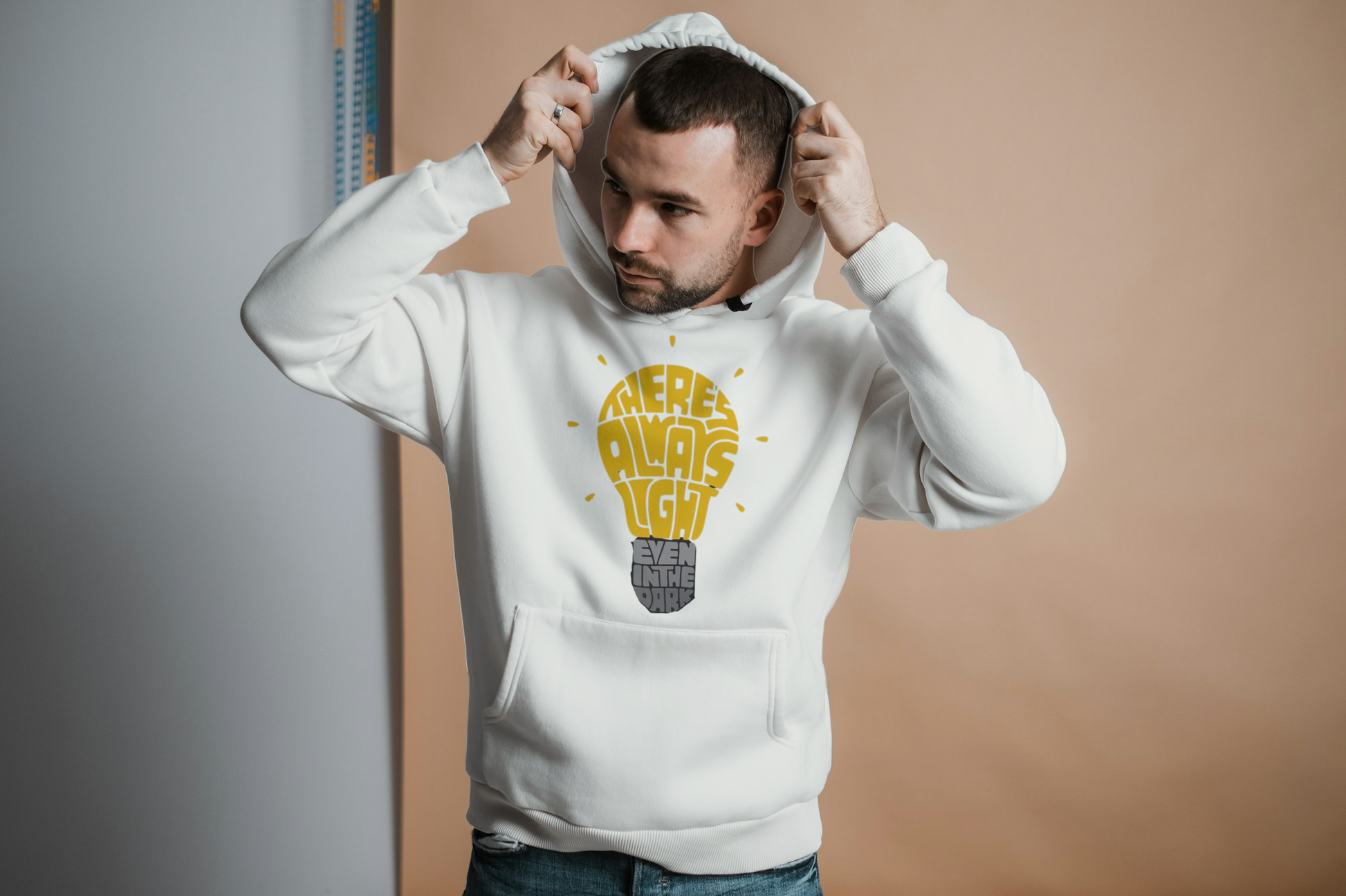 Man wearing a off white hoodie with a graphic design on a plain background